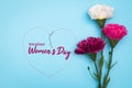 International WomenÃ¢â¬â¢s Day with flowers and heart shape necklace on blue background Royalty Free Stock Photo